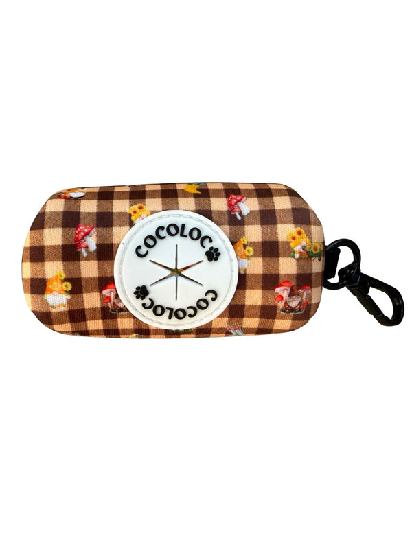 Porta bolsas Trasno con estampado vichy marrón, duendes y setas, mosquetón negro y logo COCOLOCO