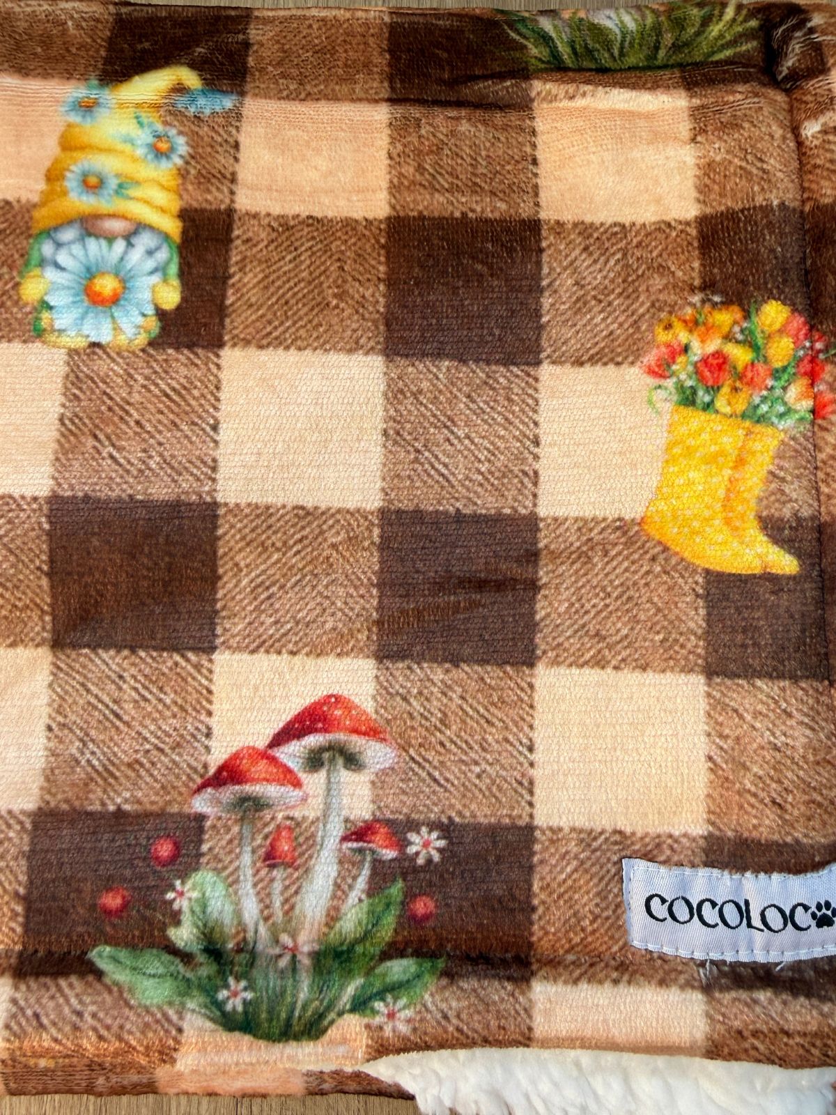 Detalle del estampado de la manta Trasno: duende con margaritas, botas amarillas con flores y setas